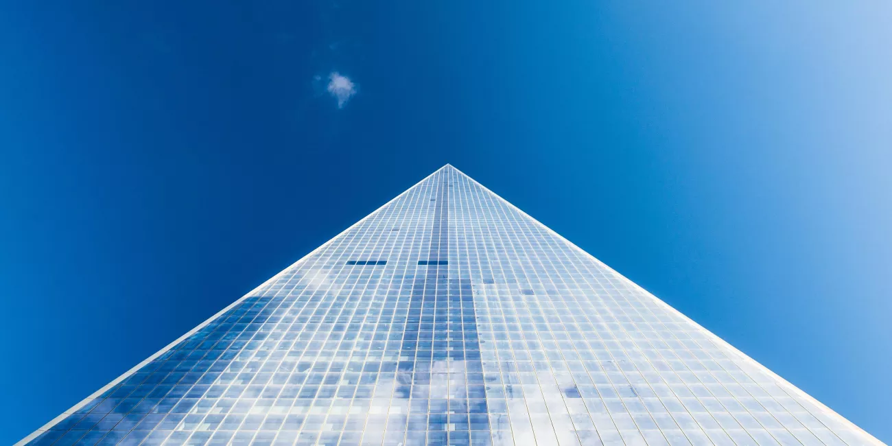 Looking up at a glass building and sky